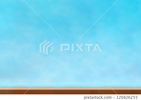 A brown wooden table in front of a blurred blue background A brown wooden table in front of a blurred blue background 120826255