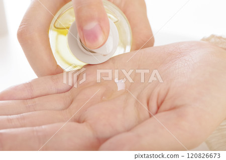A woman pouring beauty essence out of a bottle A woman pouring beauty essence out of a bottle 120826673