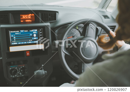 A woman driving while listening to music 120826907