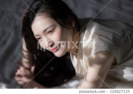 Cosmetic and beauty image of a beautiful woman relaxing in the sunlight with beautiful shadows 120827135