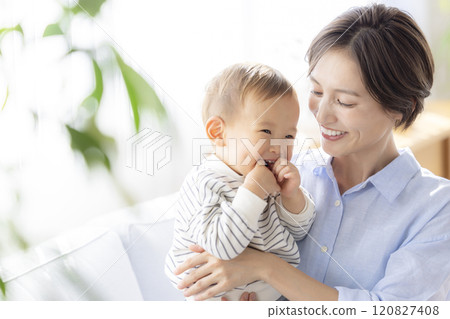 Mom and baby relaxing on the sofa 120827408