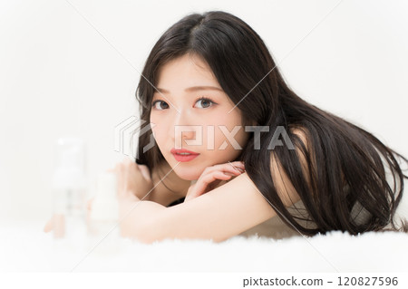 美女形象：躺在化妝品容器前的年輕女子 120827596
