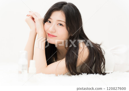 美女形象:躺在化妝品容器前的年輕女子 美女形象:躺在化妝品容器前的年輕女子 120827600