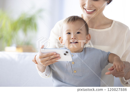 一位母親在她的智慧型手機上向她的孩子展示視頻 一位母親在她的智慧型手機上向她的孩子展示視頻 120827886