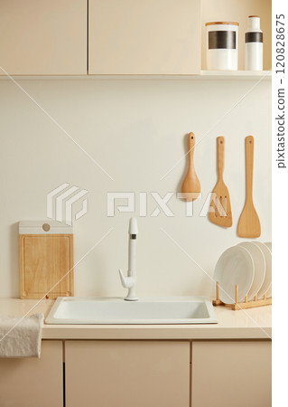 Frontal shot template photo at a white sink in beige contemporary style kitchen for hygiene product advertising. Beside, displaying a linen towel, porcelain dish and some wooden utensils Frontal shot template photo at a white sink in beige contemporary style kitchen for hygiene product advertising. Beside, displaying a linen towel, porcelain dish and some wooden utensils 120828675