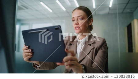 Businesswoman chatting with business partner via video call using tablet computer Businesswoman chatting with business partner via video call using tablet computer 120828816