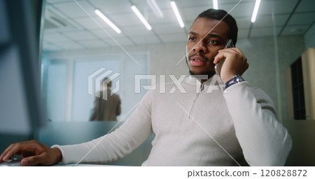 African American businessman talks to business partner about deal on mobile phone 120828872