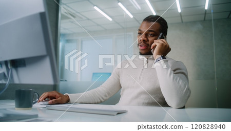 African American businessman talks to business partner about deal on mobile phone 120828940
