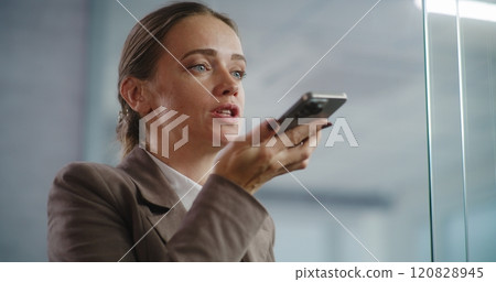 Modern office: Close up of businesswoman recording voice message using smartphone 120828945