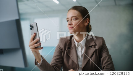 Businesswoman chatting with business partner on video call using smartphone Businesswoman chatting with business partner on video call using smartphone 120829155