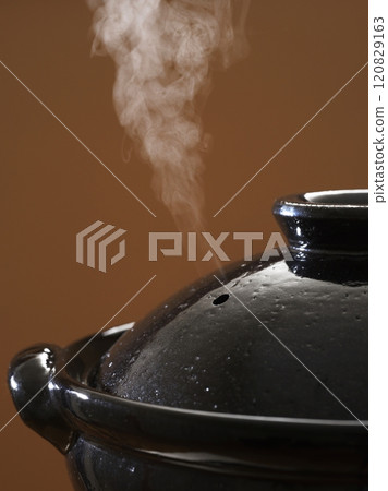 Image of hot pot cooking with steam rising from the clay pot 120829163