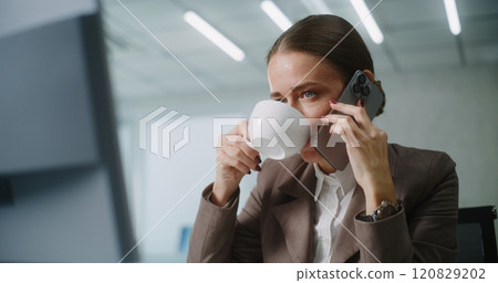 Positive E-commerce manager talks to client on mobile phone, uses computer Positive E-commerce manager talks to client on mobile phone, uses computer 120829202