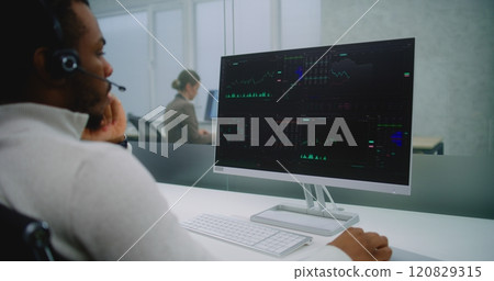 African American stockbroker in headset analyzes financial charts and diagrams on computer African American stockbroker in headset analyzes financial charts and diagrams on computer 120829315