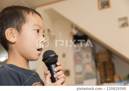 Elementary school boy doing karaoke at home 120829390