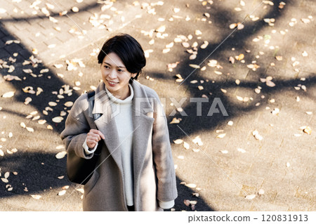 Woman wearing a coat in the autumn park Woman wearing a coat in the autumn park 120831913