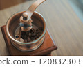 Vintage coffee grinder with beans on a wooden surface 120832303