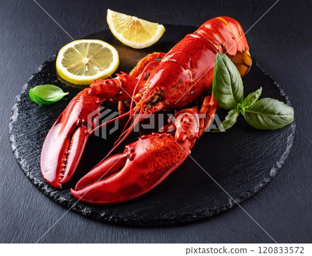 Boiled lobster with lemon and basil on a black slate board Boiled lobster with lemon and basil on a black slate board 120833572