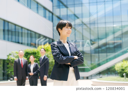 A young woman with her arms folded in front of a building A young woman with her arms folded in front of a building 120834001