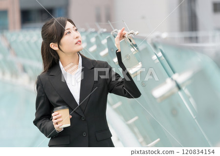 Business woman relaxing with takeaway coffee Business woman relaxing with takeaway coffee 120834154