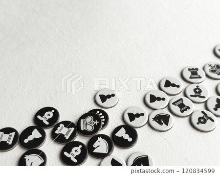 Chess themed tokens on white surface. Strategic game pieces in black and white Chess themed tokens on white surface. Strategic game pieces in black and white 120834599