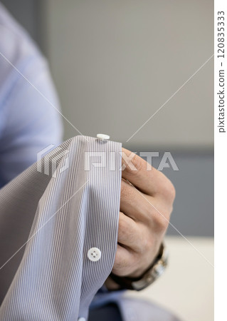 Male tailor with button in studio Male tailor with button in studio 120835333
