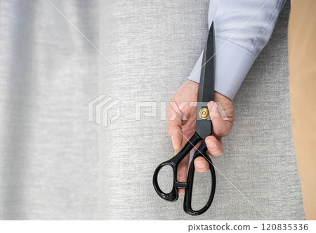 Hand in shirt holding scissors. 120835336