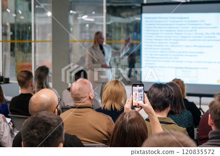 Speaker presenting to engaged audience at business conference in modern office setting 120835572