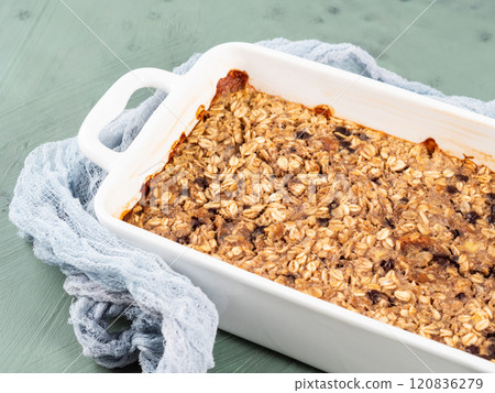 Oatmeal porridge granola cake in white baking tray on green 120836279