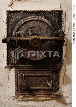Antique cast iron furnace door with intricate details and a weathered surface 120837120