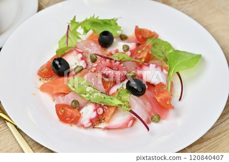 生牛肉片,生牛肉片沙拉。鮭魚、鯛魚、章魚、櫻桃番茄、嫩葉和橄欖油。 生牛肉片,生牛肉片沙拉。鮭魚、鯛魚、章魚、櫻桃番茄、嫩葉和橄欖油。 120840407