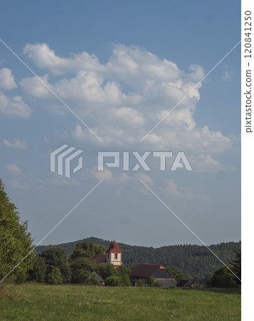 Summer view of old historical Bohemian village Zdirec Borejov with Church of St. James in in Baroque architectural style and green meadow and trees, Kokorin region, central Bohemia 120841250