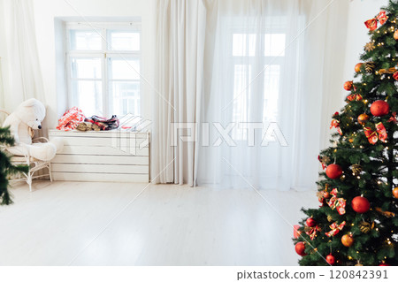 Christmas tree with gifts decorated with red toys lights garland in the interior for the new year 120842391