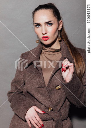 Beautiful slender woman in winter coat on gray background 120843173
