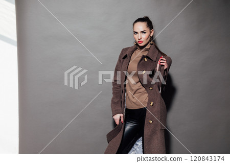 Beautiful slender woman in winter coat on gray background 120843174