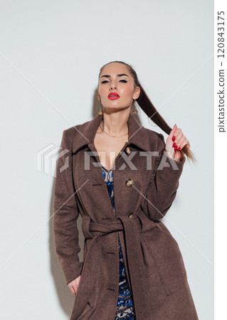 Beautiful slender woman in winter coat on gray background Beautiful slender woman in winter coat on gray background 120843175