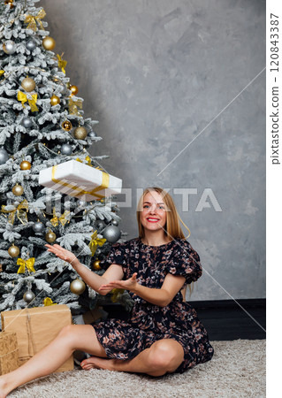 Beautiful blonde woman decorating Christmas tree toys for new year 120843387