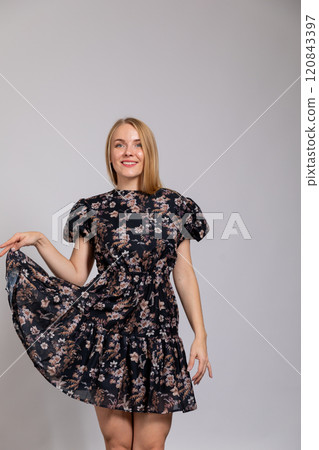 Beautiful woman smiling in summer dress on gray background 120843397