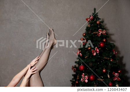 Slender female legs in pantyhose for Christmas 120843407
