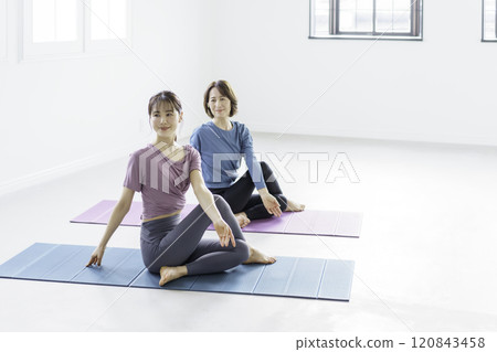 瑜珈:一名年輕女子和一名中年女子做半魚王式 瑜珈:一名年輕女子和一名中年女子做半魚王式 120843458