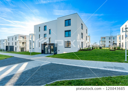 Modern residential complex with green areas and pathways on sunny day Modern residential complex with green areas and pathways on sunny day 120843685