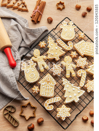 Christmas cookies cooling on rack with festive shapes and decorations, 120843885