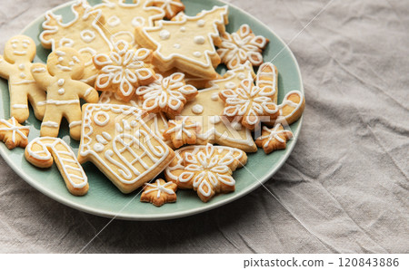 Christmas cookies with white icing forming various shapes lying on a plate Christmas cookies with white icing forming various shapes lying on a plate 120843886