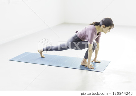 Young woman doing yoga low lunge pose 120844243