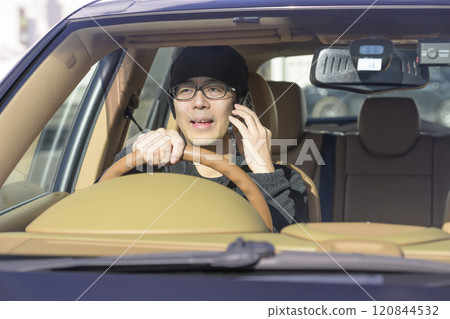 Image of a man driving while talking on his smartphone 120844532