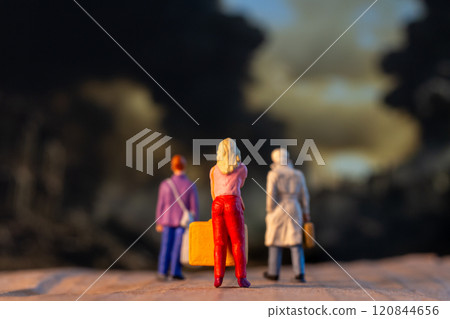 Miniature figures carrying luggage walk against a somber backdrop, symbolizing displacement and the human cost of war Miniature figures carrying luggage walk against a somber backdrop, symbolizing displacement and the human cost of war 120844656