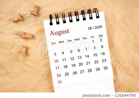 August 2025 white desk calendar with wooden thumbtack on old  crumpled paper. 120844790