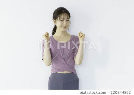一位年輕女子穿著瑜珈服，做拳頭泵 120844892