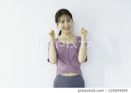 一位年輕女子穿著瑜珈服,做拳頭泵 一位年輕女子穿著瑜珈服,做拳頭泵 120844895