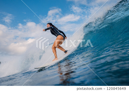 Surfer girl and crashing wave. Surfer woman on surfboard during surfing. Surfer girl and crashing wave. Surfer woman on surfboard during surfing. 120845649