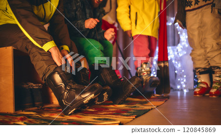 Close-up shot of ski boots being adjusted, showing vibrant colors and textures, highlighting the excitement of cozy pre-ski preparation scene. 120845869